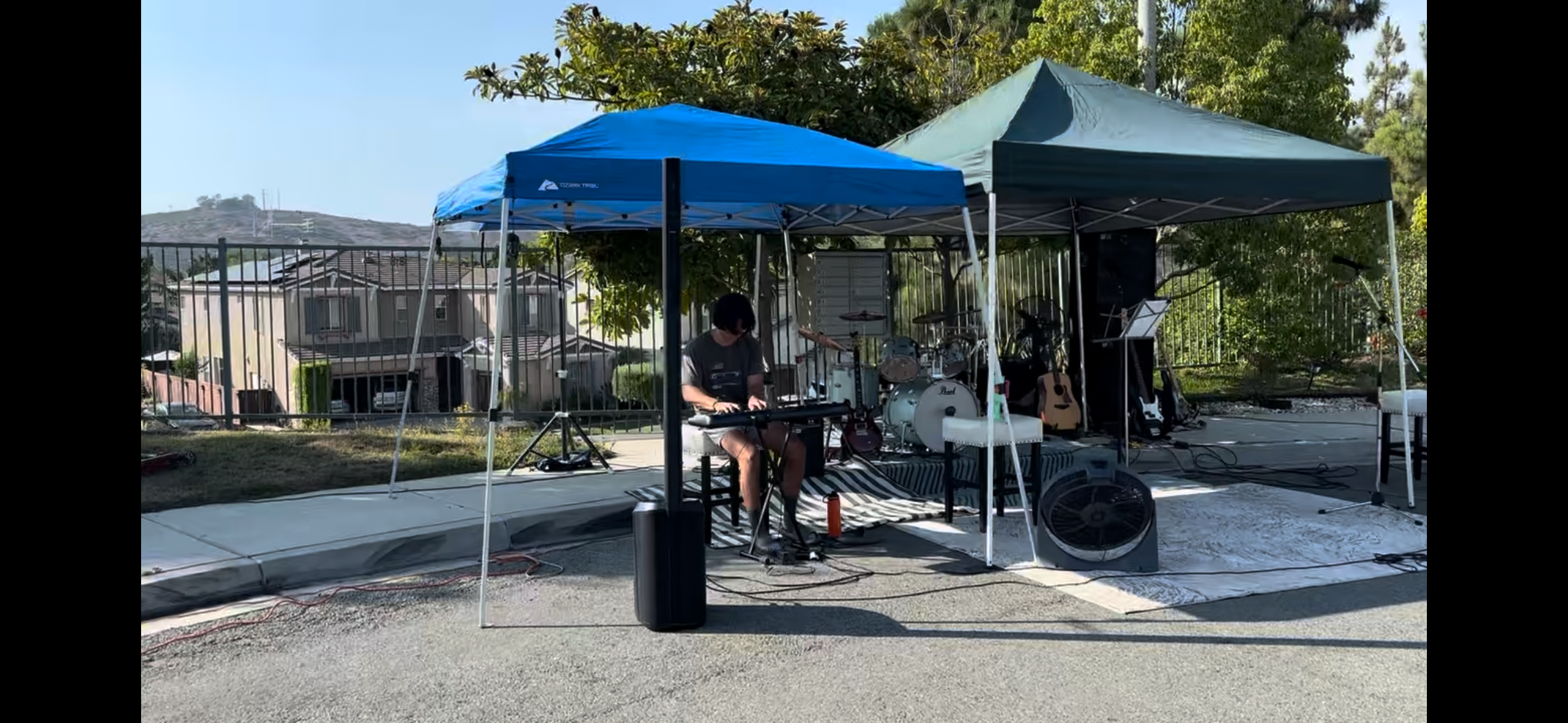 Liam performing keyboard outdoors with a band