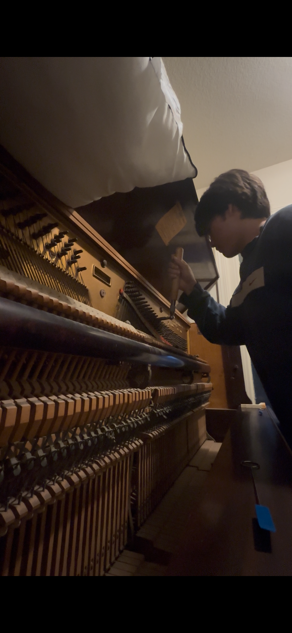 Liam working inside an upright piano